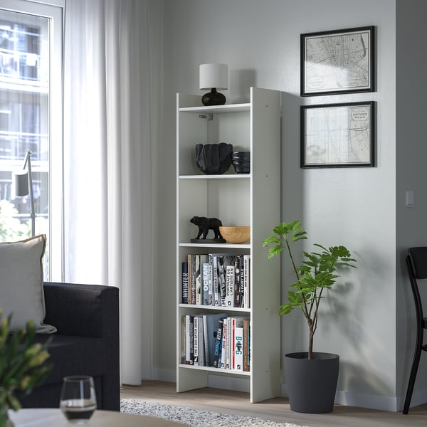 Minimalist white BAGGEBO bookshelf with lamp, books, and decor in living room.