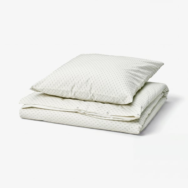 Folded white cotton duvet set with green woven details.