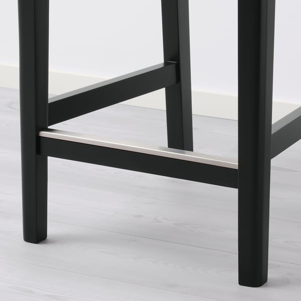 Black metal barstool with sleek design, angled backrest, and sturdy legs.