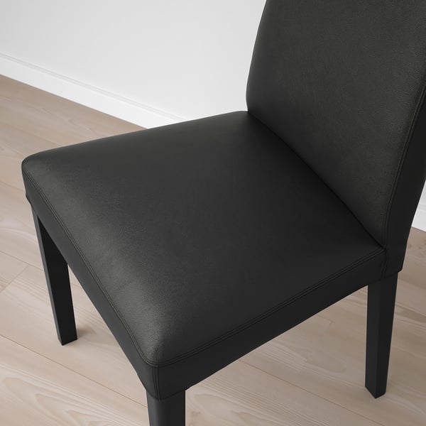 A modern black leather chair with a cushioned seat and back, designed for comfort and durability.