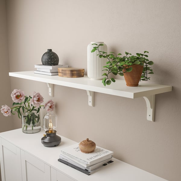Wall shelf with decorative items: plants, books, vases, and flowers.