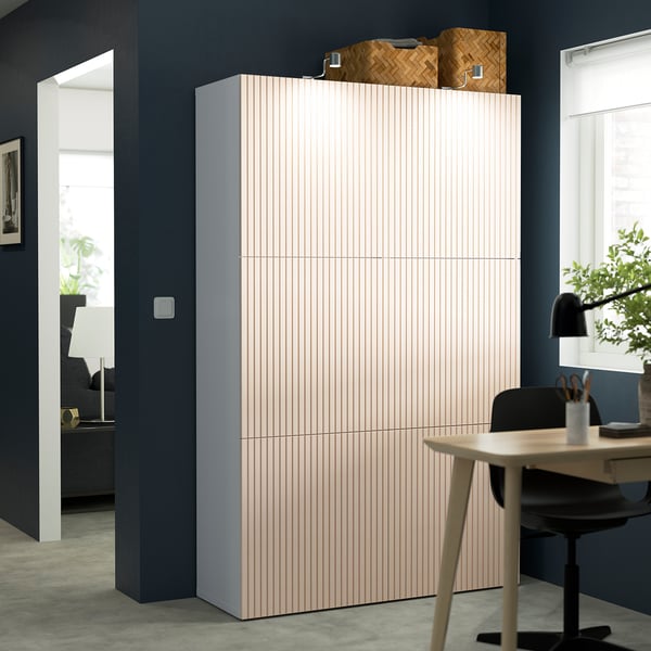 Modern office with light grey BESTÅ cabinet, black desk, and chair.