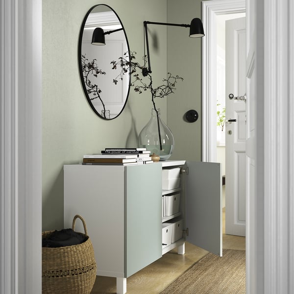 Modern sideboard with open doors, storage, mirror, light, and basket.