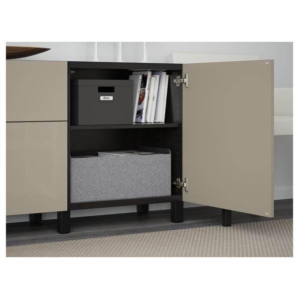 Open beige sideboard displaying storage with boxes and books, showcasing organized space.