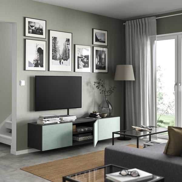 Modern living room with BESTÅ tv stand, featuring black tv, grey curtains, and decorative photos.
