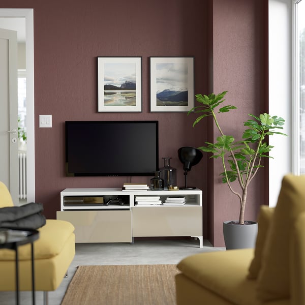 Contemporary living room: flat-screen tv on wide media console with open shelves, framed mountain prints, yellow sofa, plant.