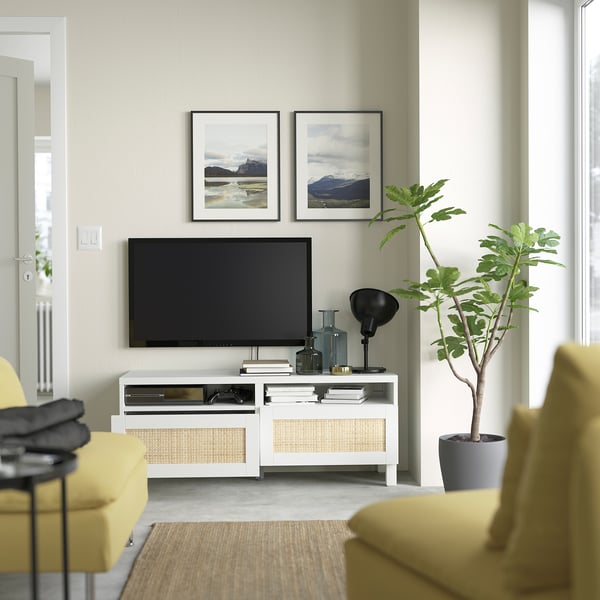 Modern living room with tv on white stand, featuring cable management, drawers, and natural decor.