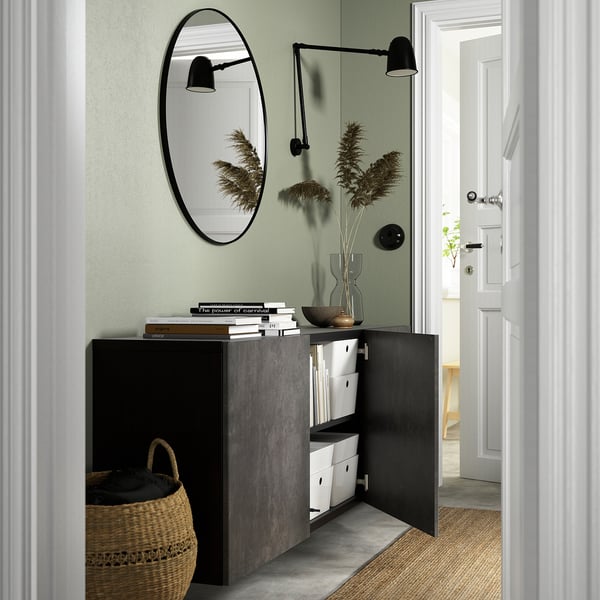 Modern wall-mounted cabinet with open doors, displaying organised storage solutions and a mirror above.