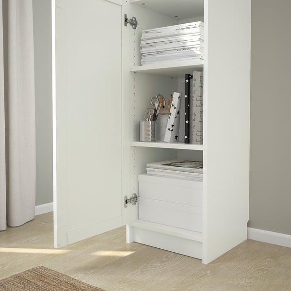 White BILLY bookcase with adjustable shelves; displays and stores books and items; anchored to wall, three shelves visible.