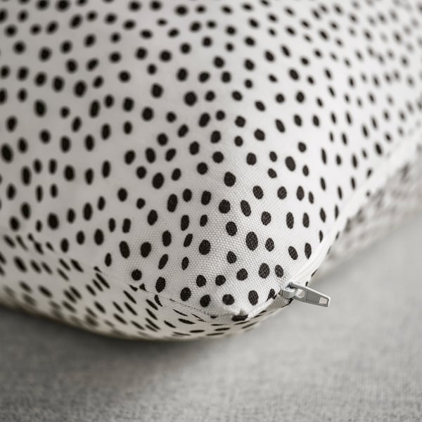 Close-up of soft, high-quality fabric with black dots on white background. Hidden zip visible at edge.