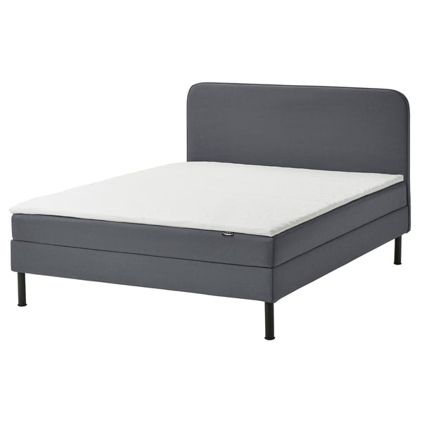 Gray divan bed with white mattress, padded headboard, modern design.