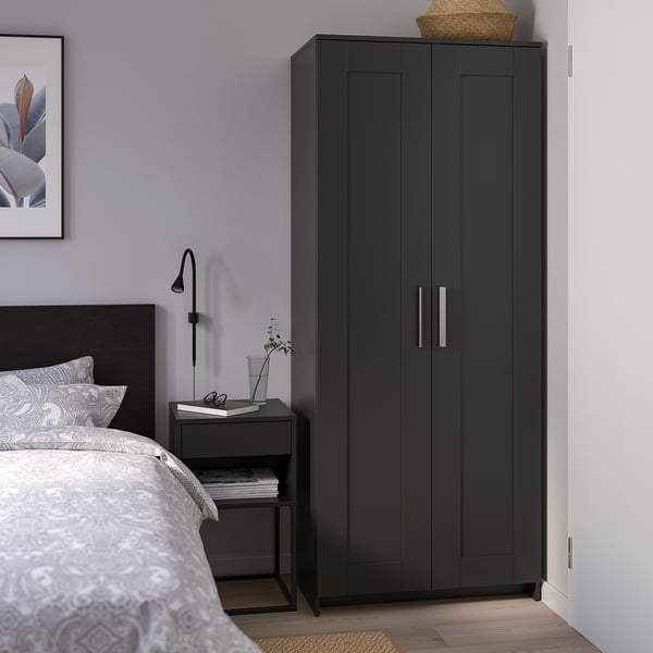 Modern black BRIMNES wardrobe between ikea bed & side table, stylish & practical storage.