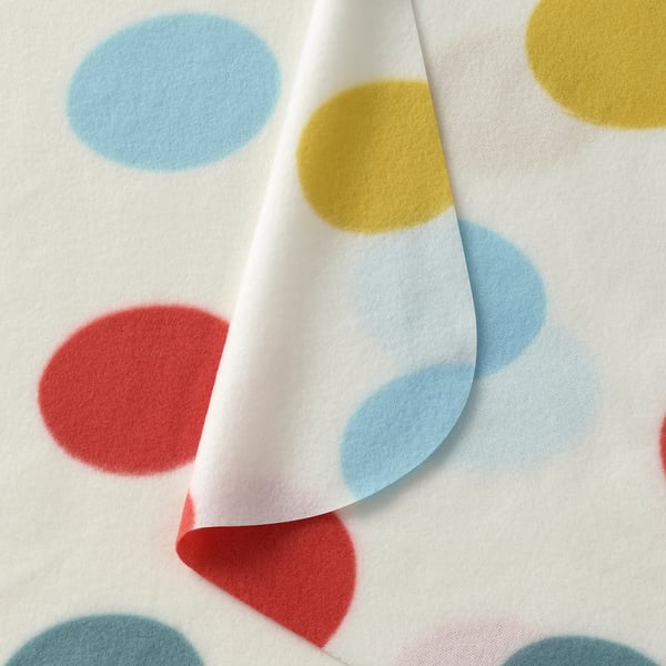 Multicoloured polka-dot throw with red, yellow, and blue dots on white.