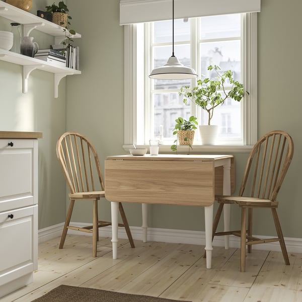 Small DANDERYD light wood drop-leaf table with two chairs near a window, decorated with a plant.