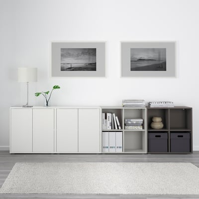 White EKET storage with mix of closed and open shelves, black & white photos, lamp, books, decor, soft rug.