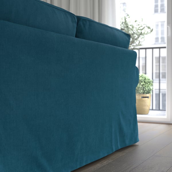 Blue sofa by window, soft cushions, removable cover.
