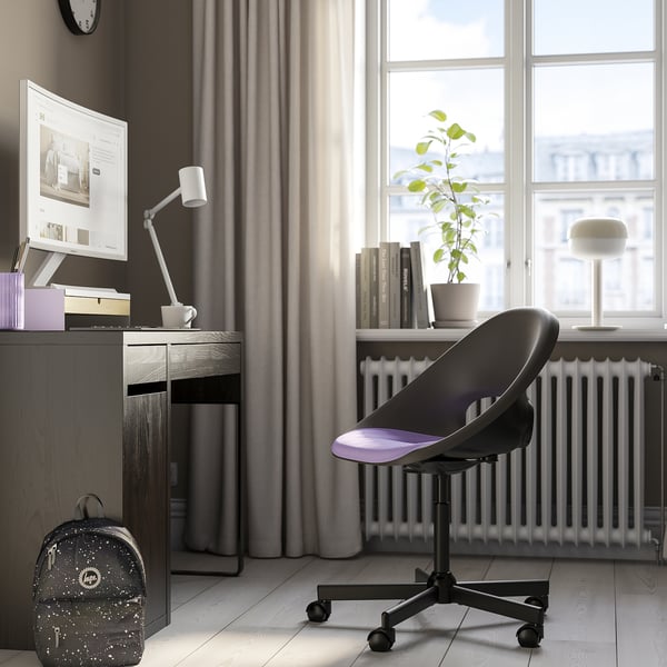 Home office with ELDBERGET black desk chair, modern & comfortable, fits under desk, near window with plant, computer setup.