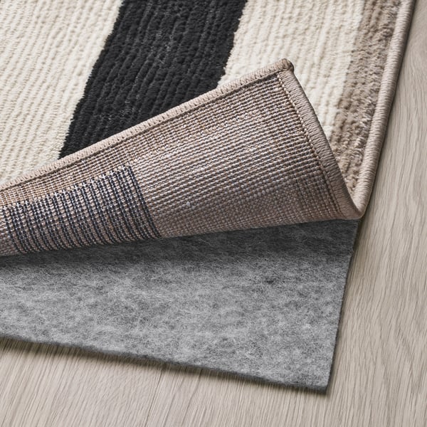 Felt rug underlay placed under patterned rug for stability and comfort.