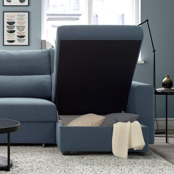 Modern blue sofa with adjustable headrests and extendable footrests, showcasing a cosy nest for relaxation with blankets and pillows.