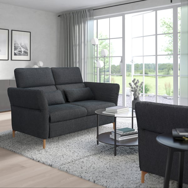 Modern living room with FAMMARP sofa, rug, tables, lamp, plant, curtains, and art.