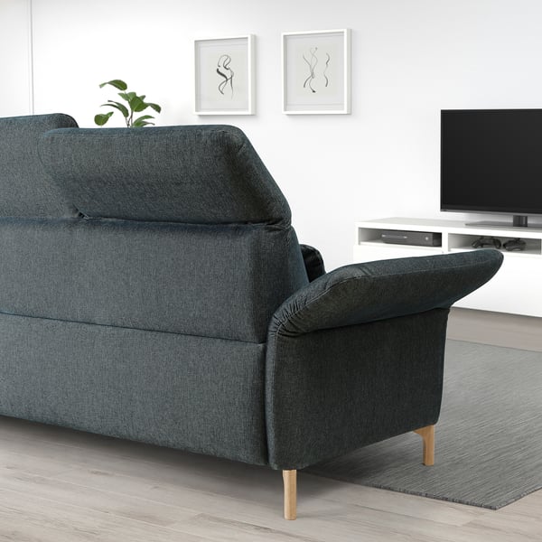 A FAMMARP sofa in grey with a textured pattern, medium size, and wooden legs. It has adjustable cushions and sits below a tv and wall art.