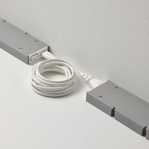 Two rectangular devices connected by a white cord for linking and controlling multiple lamps with a single power supply.