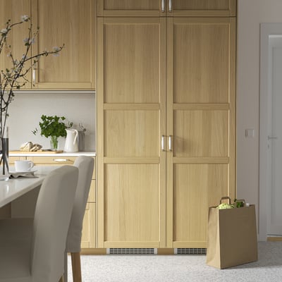 Modern kitchen with FORSNÄS freezer in cabinets, silver handles, and counter decor.