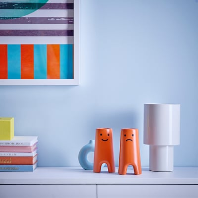 Two FRÖVÄXT vases on table, with lamp and books.