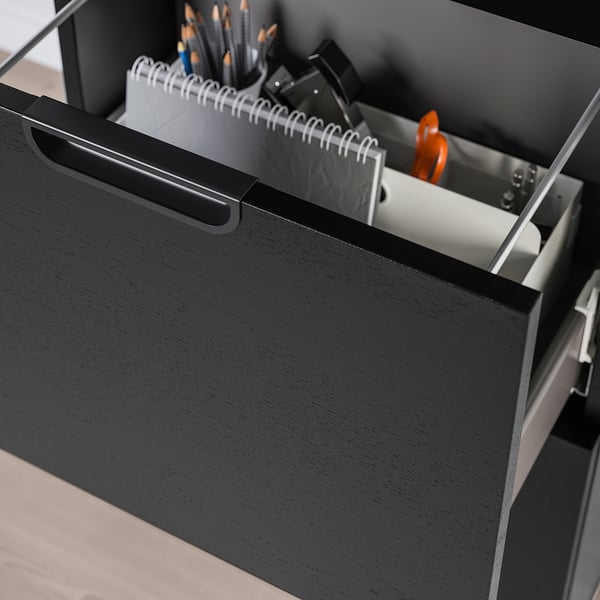 Open black office cabinet showing supplies: pencils, notepad, ruler, with combination lock for secure storage.