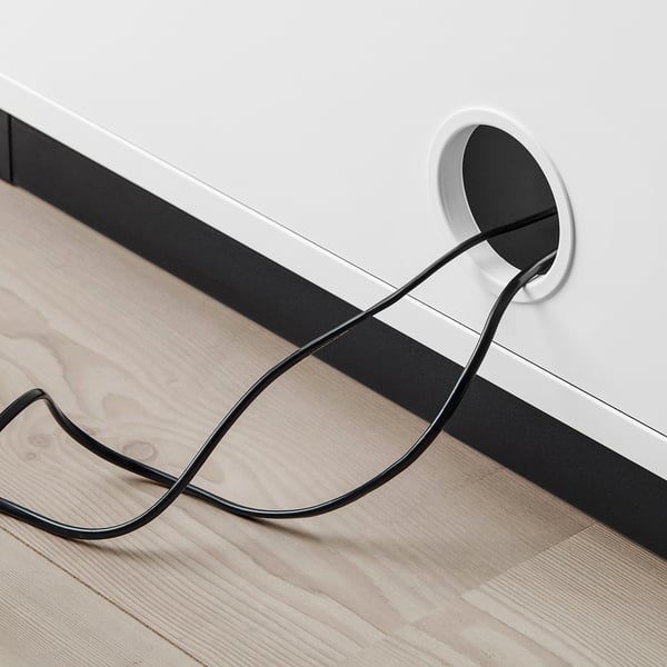 A modern desk with a circular power outlet, showing cable management through a hole, promoting organised and clutter-free workspace.