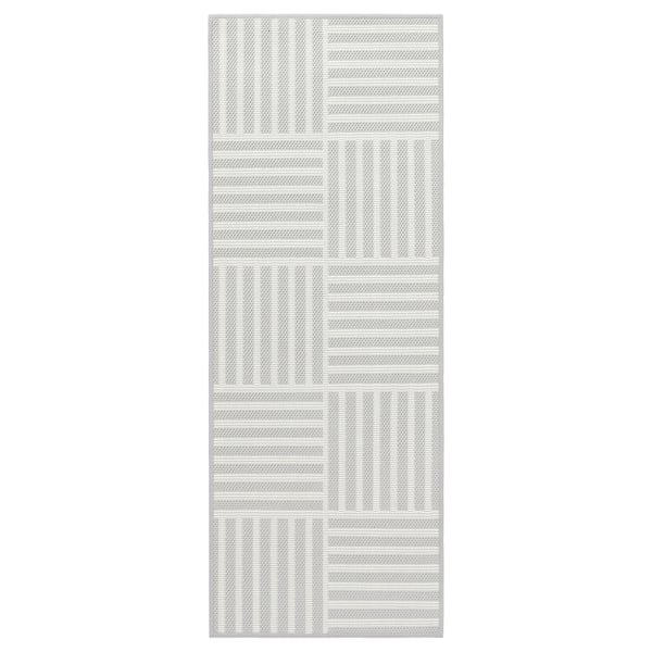 The GATUSEKTION mat is a grey and white striped, rectangular, machine-washable kitchen rug with a chequered pattern.