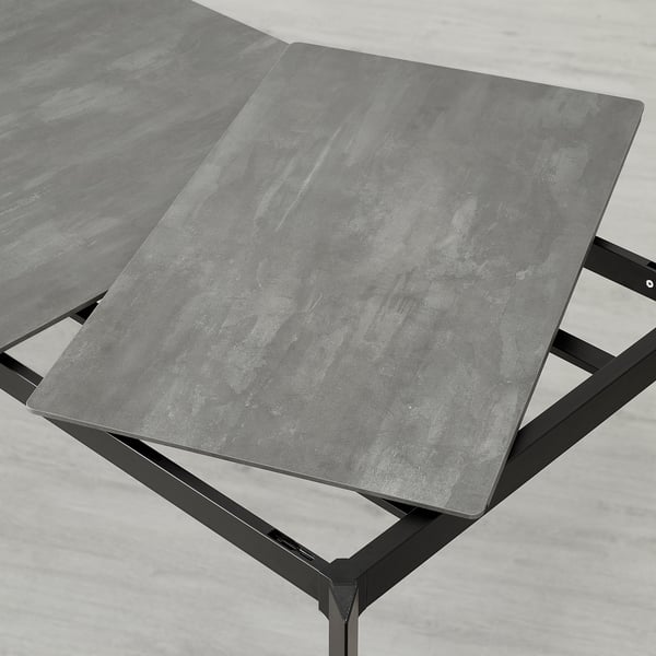 Extendable dining table with sleek design in photo. Grey embossed stone-like top, durable, and easy to clean. Aluminium legs provide sturdy support.
