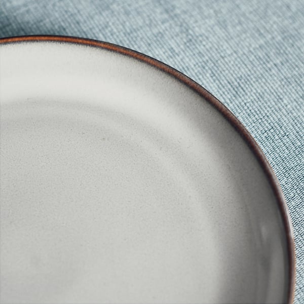 Elegant, textured side plate with rustic edge on blue denim.