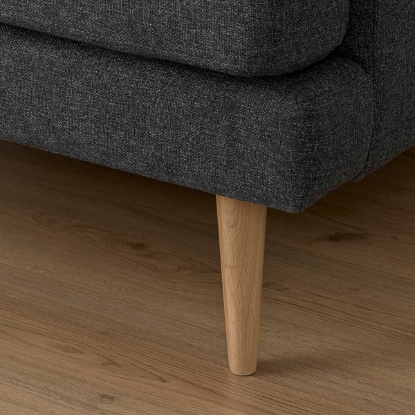 Close-up of a stylish sofa leg, sleek design, high-quality fabric, and sturdy wood for stability.