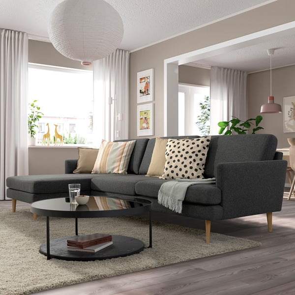 Modern living room with grey GRILLSTORP sofa, patterned pillows, round coffee table, large window, and decor.