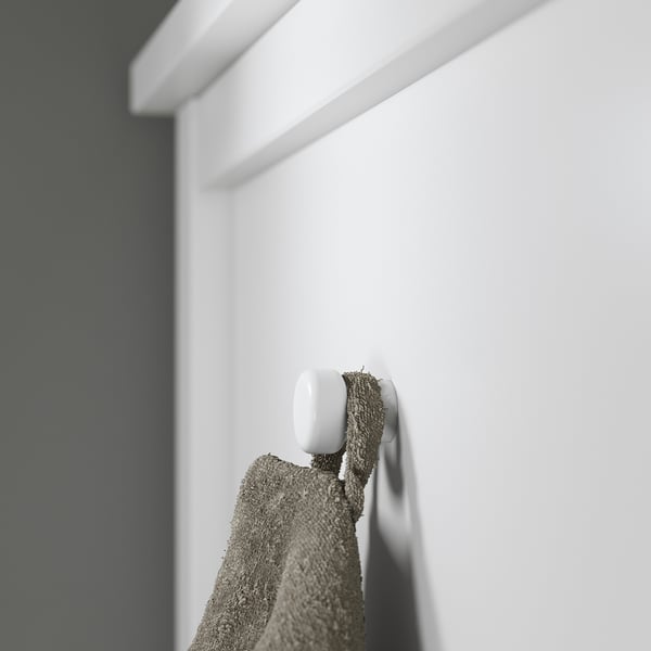 White hook with grey towel hanging against a white wall.