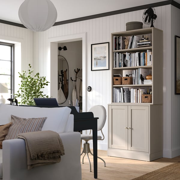 Home office with HAVSTA shelves, books, sofa & chair. Large window with natural light.