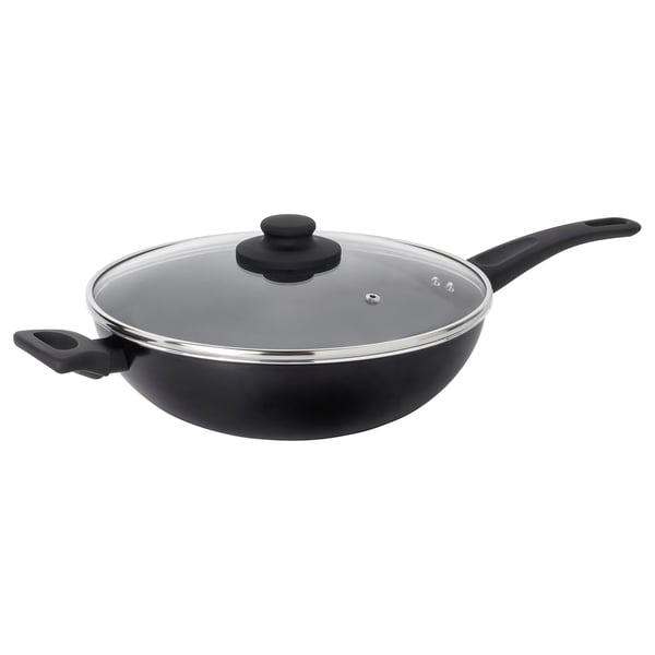 The HEMLAGAD wok in black with glass lid and two handles is ready for stir-frying.