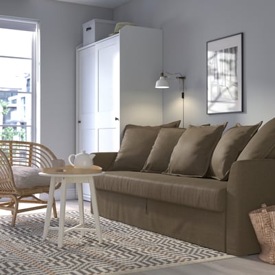 HOLMSUND sofa-bed in brown, ideal for small rooms, with ample storage and a spacious bed.