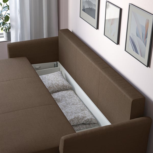 Sofa with pull-out bed and storage. Brown upholstery with patterned bedding visible.