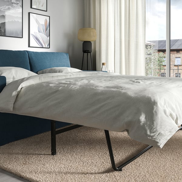 Modern bedroom with HYLTARP sofa-bed, showcasing clean design, comfy cushions, and easy bed conversion.