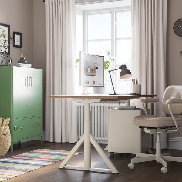 Home office with IDÅSEN desk, chair, and decor. Warm rug, large window, calm colours.