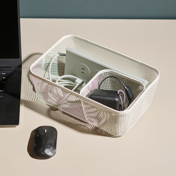 Mesh basket organises tech accessories next to a laptop and mouse. Holds cables, headphones, and charging devices neatly.