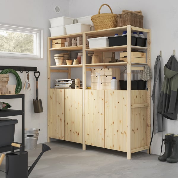 Wooden IVAR shelves hold gardening tools and supplies. Tall, light pine with various baskets and containers, fitting neatly next to coats and boots.