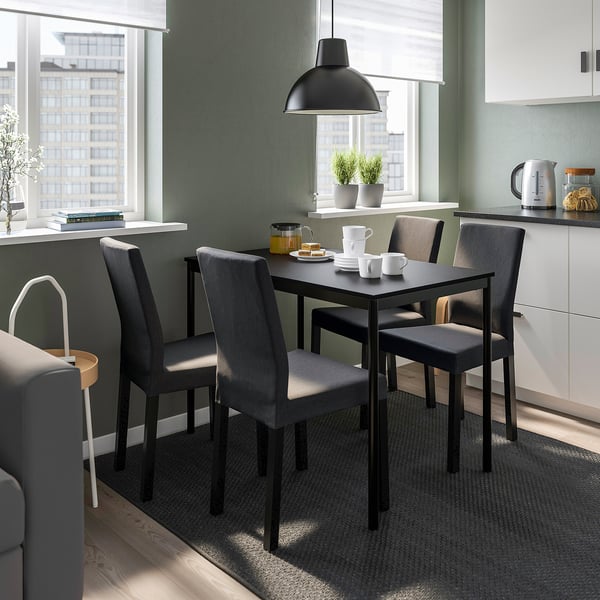 Modern dining area with KÄTTIL chairs & table, urban views, cosy decor.