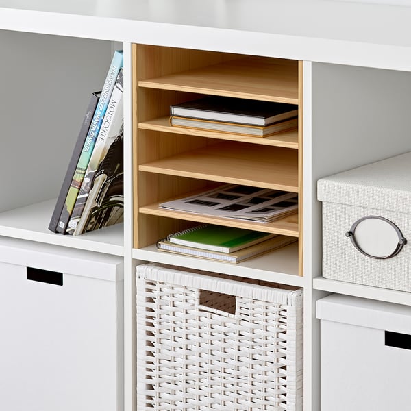 White KALLAX shelf with wooden dividers organising books and magazines.
