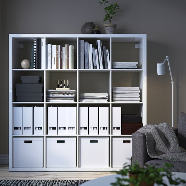 KALLAX white shelving unit with books, boxes, decor. Modern, tall, fits large rooms.