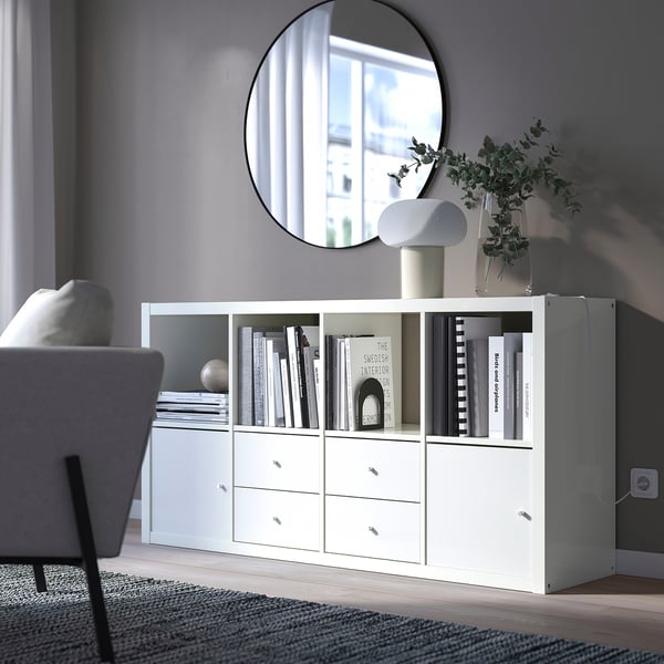 Modern living room with KALLAX sideboard, books, mirror, lamp, and cosy chair.