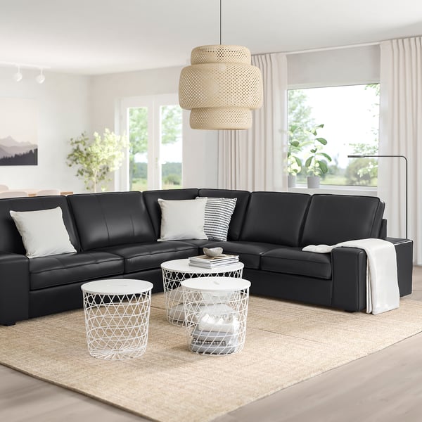 Modern living room with KIVIK sectional, side tables, large windows, rug, pendant light, minimalist design.