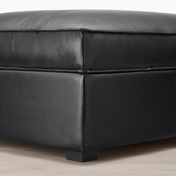 Black leather upholstered ottoman with square legs, showcasing high-quality grain leather and durable construction.